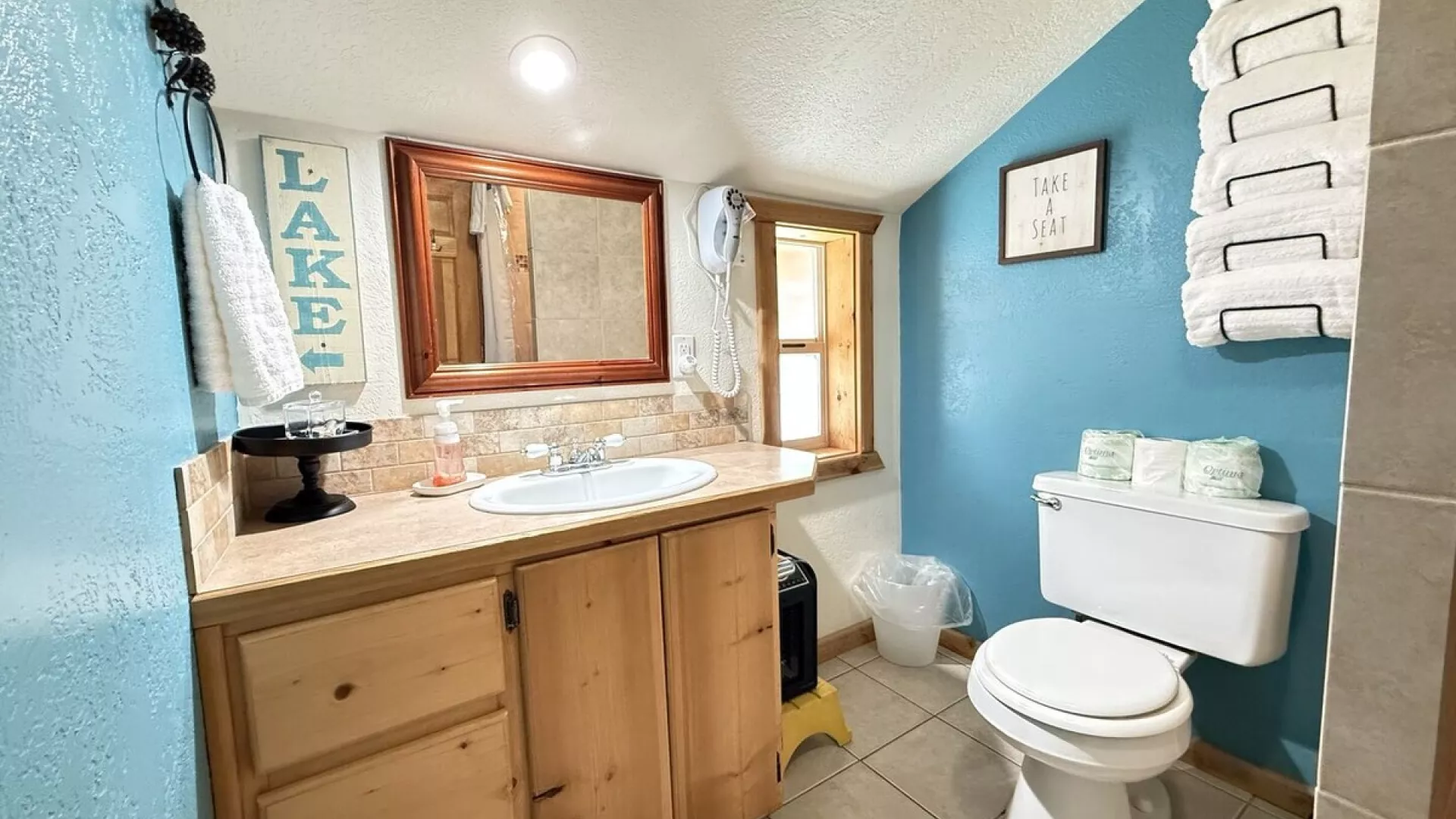 Upstairs bathroom with a full sink vanity, toilet, and standing shower.