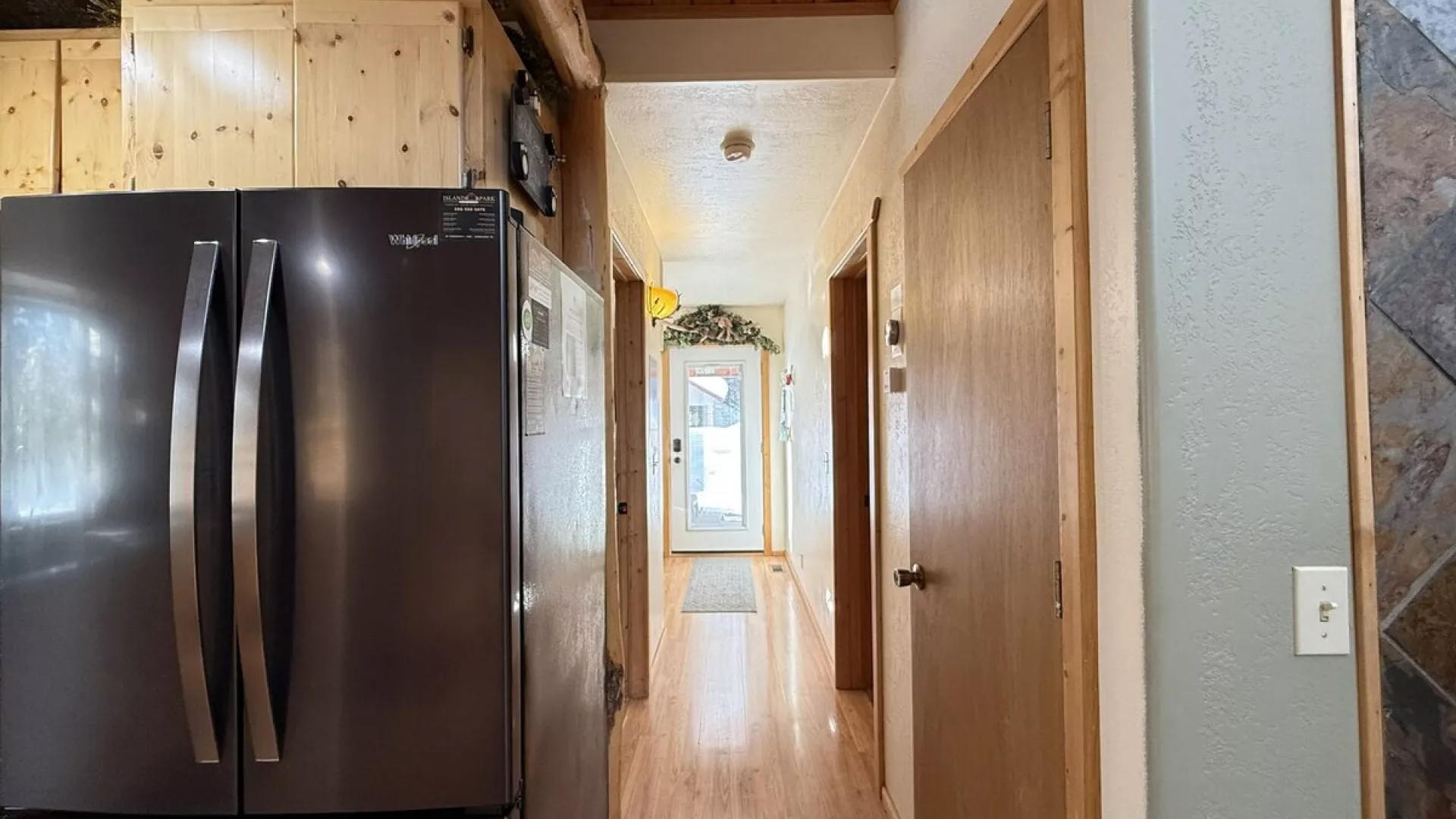 Hallway view of the kitchen and access to the bathroom and laundry room ahead.