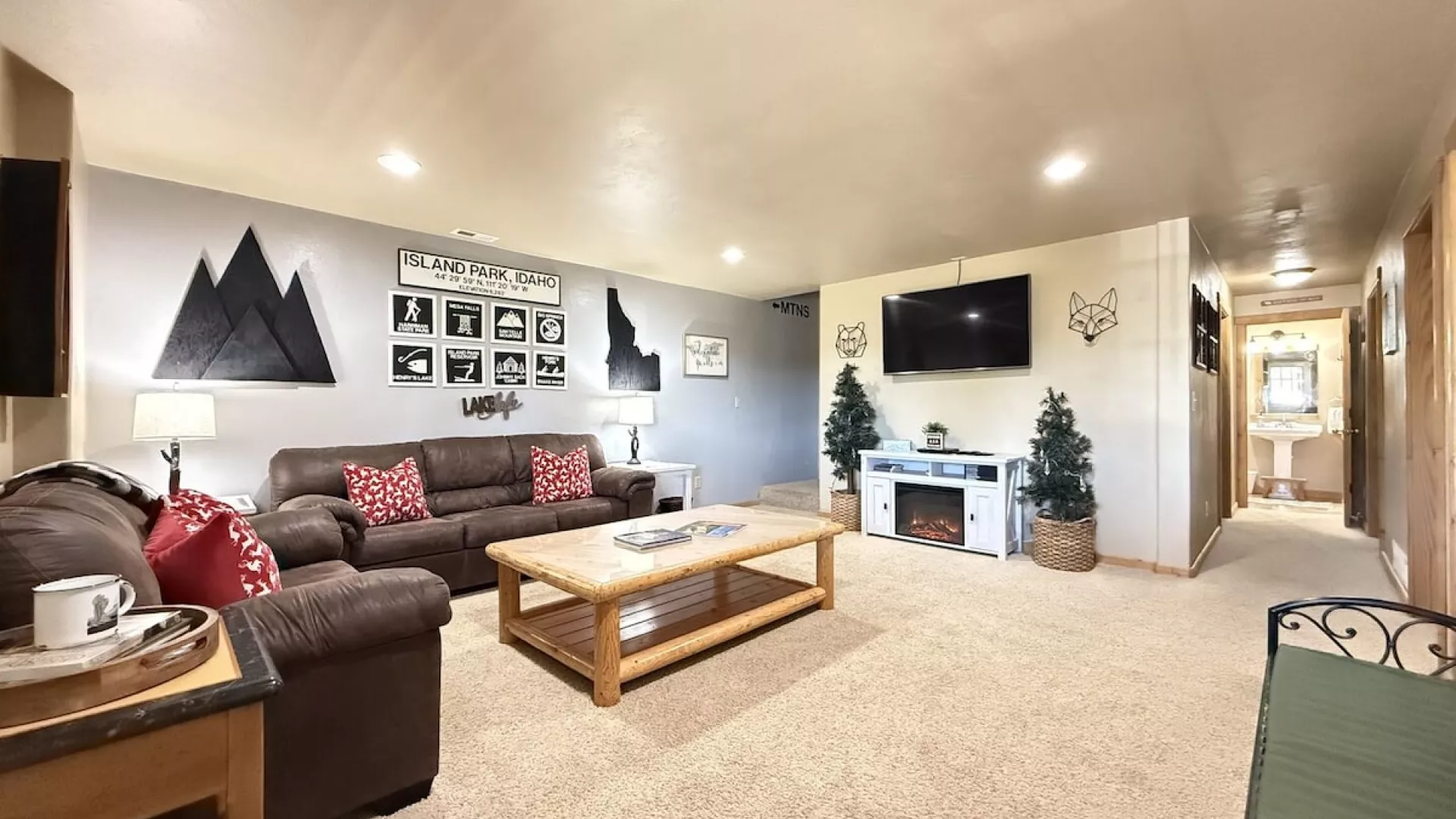 Upon entrance of the cabin you view the downstairs living room. Equipped with a smart tv and seating to relax during your stay.