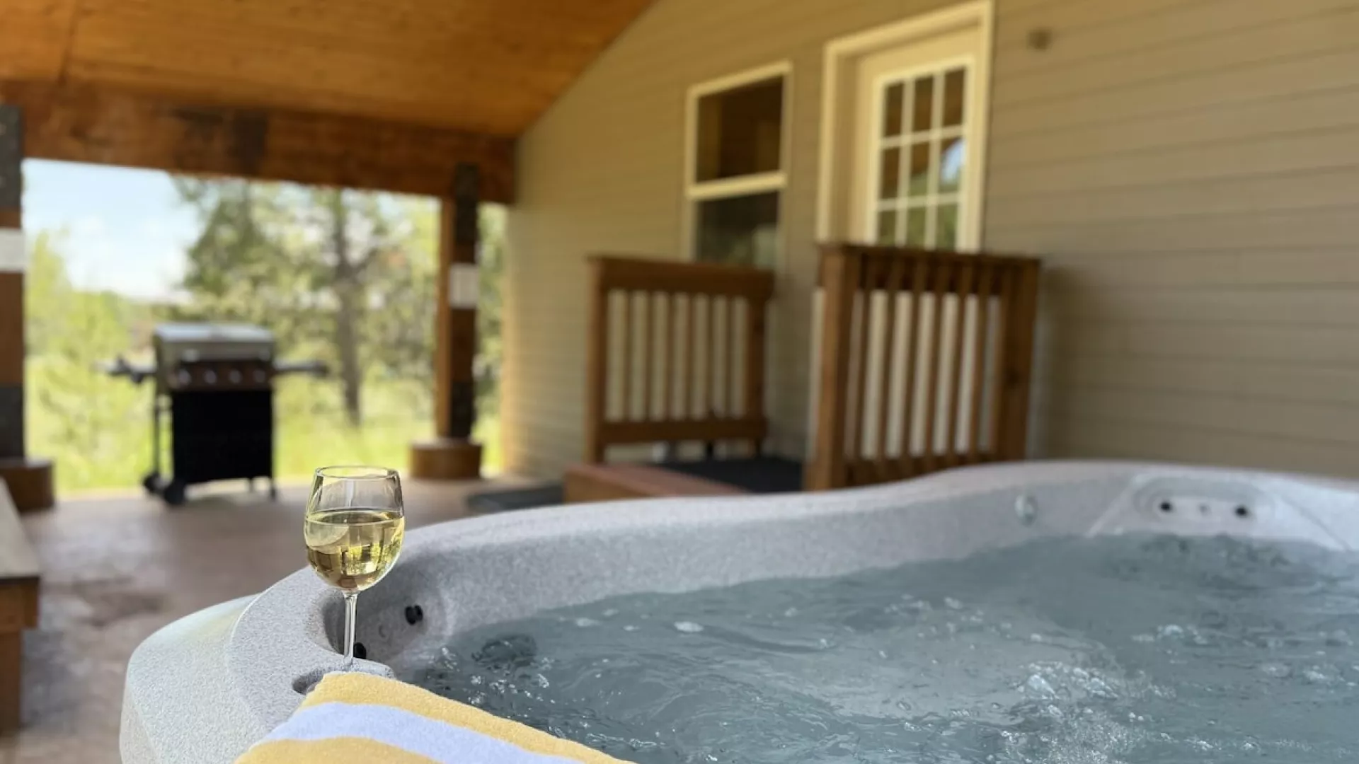 Hot tub and grill are conveniently located outside in the back of the cabin.