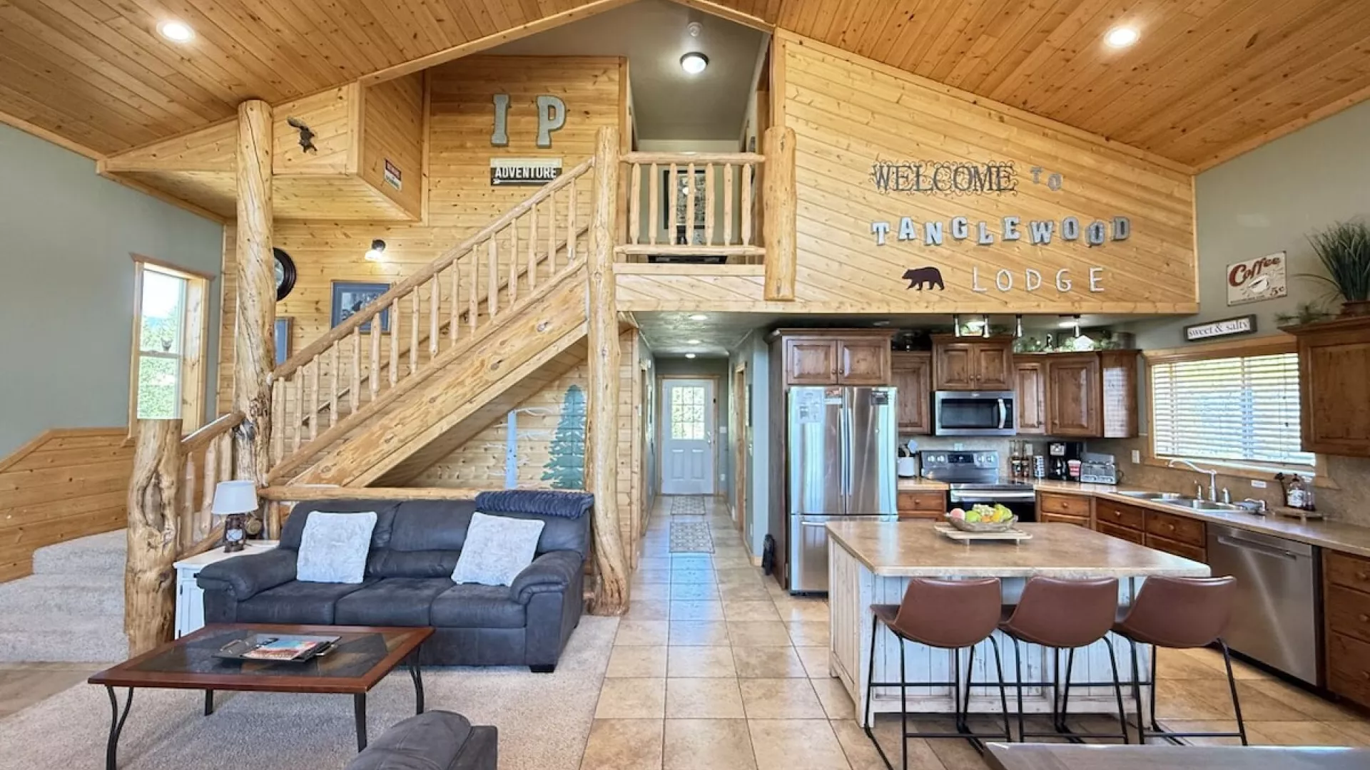 Access to the third level is up the stairs. The open kitchen blends seamlessly into the cabin's cozy living area, creating a welcoming space perfect for gathering and unwinding.