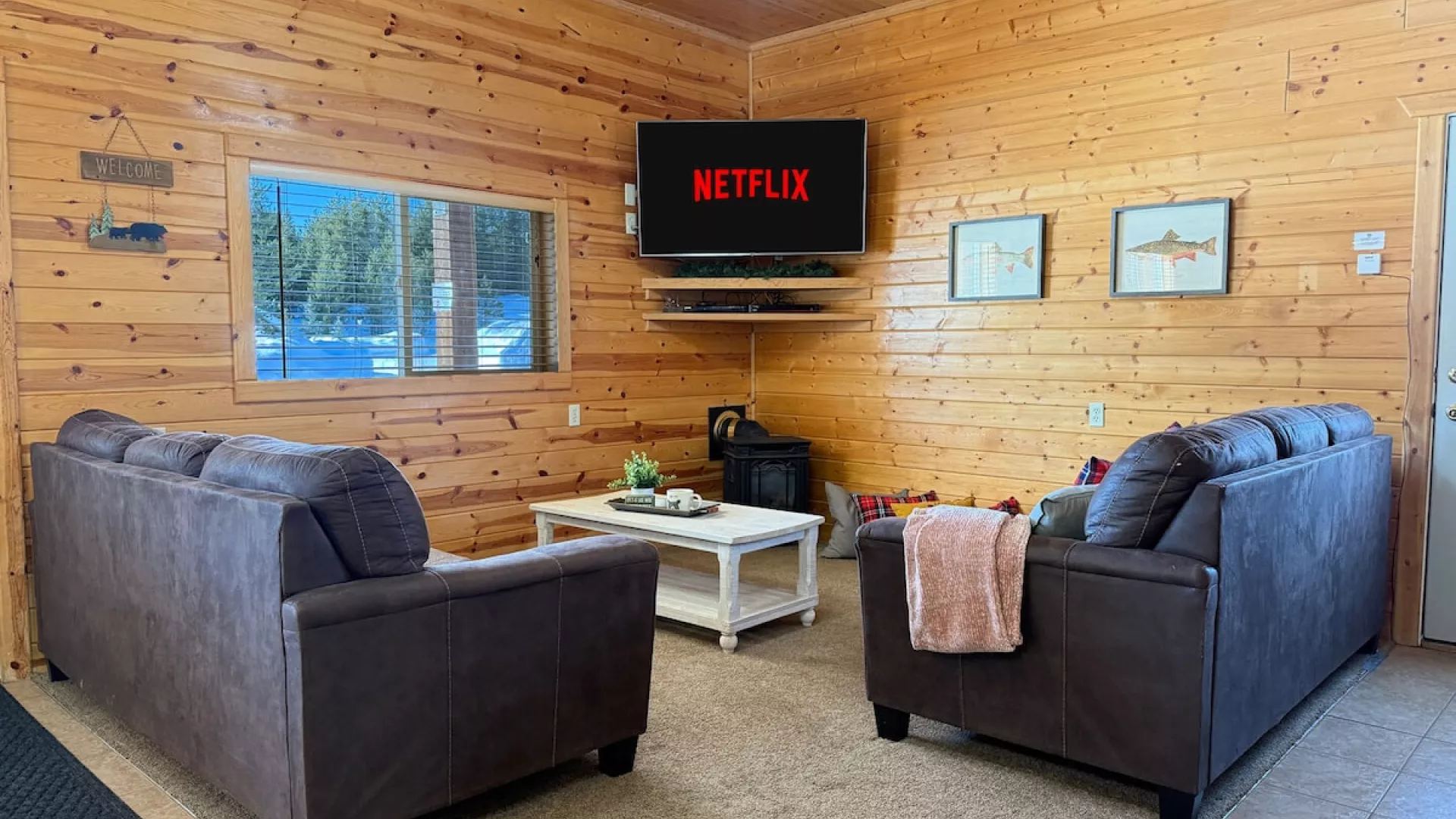 Picture a warm, open-concept living room with a cabin vibe—wood tones, soft textures, and a layout that encourages conversation and connection.