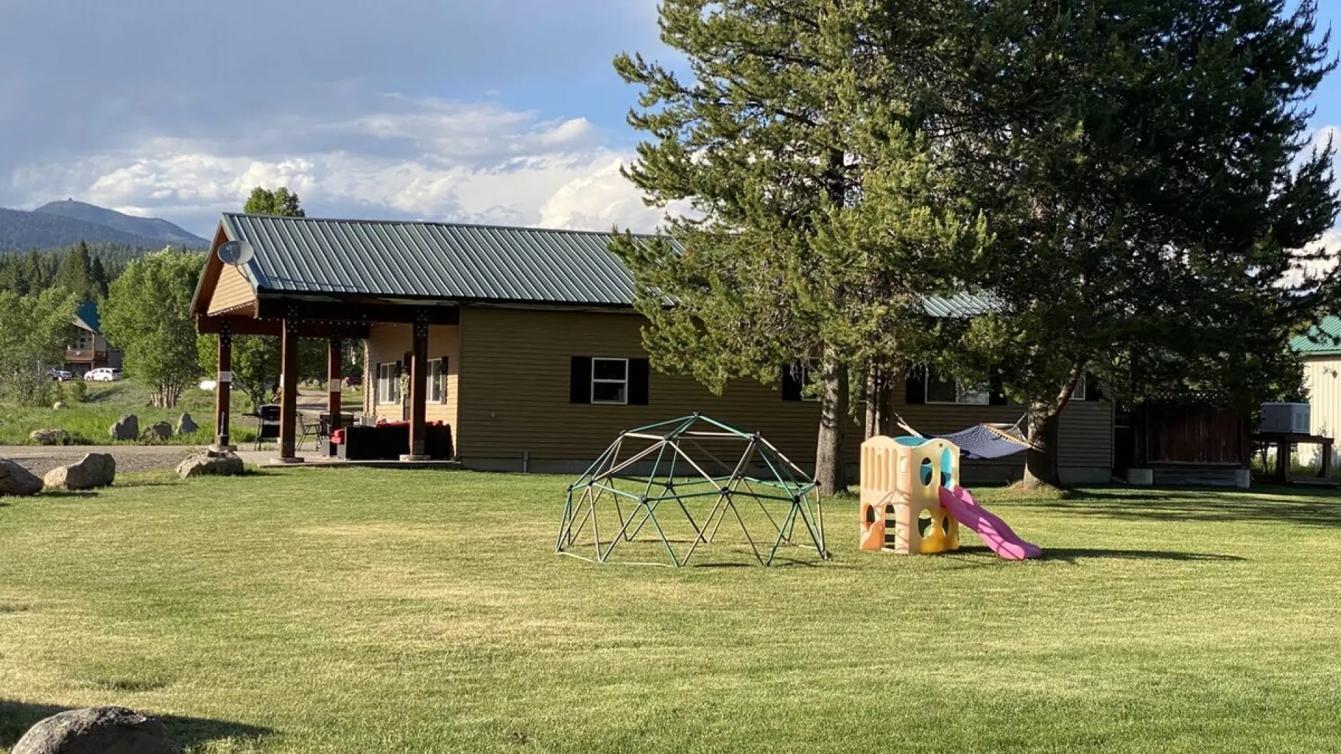Large grass area and small play set is located adjacent to the cabin.