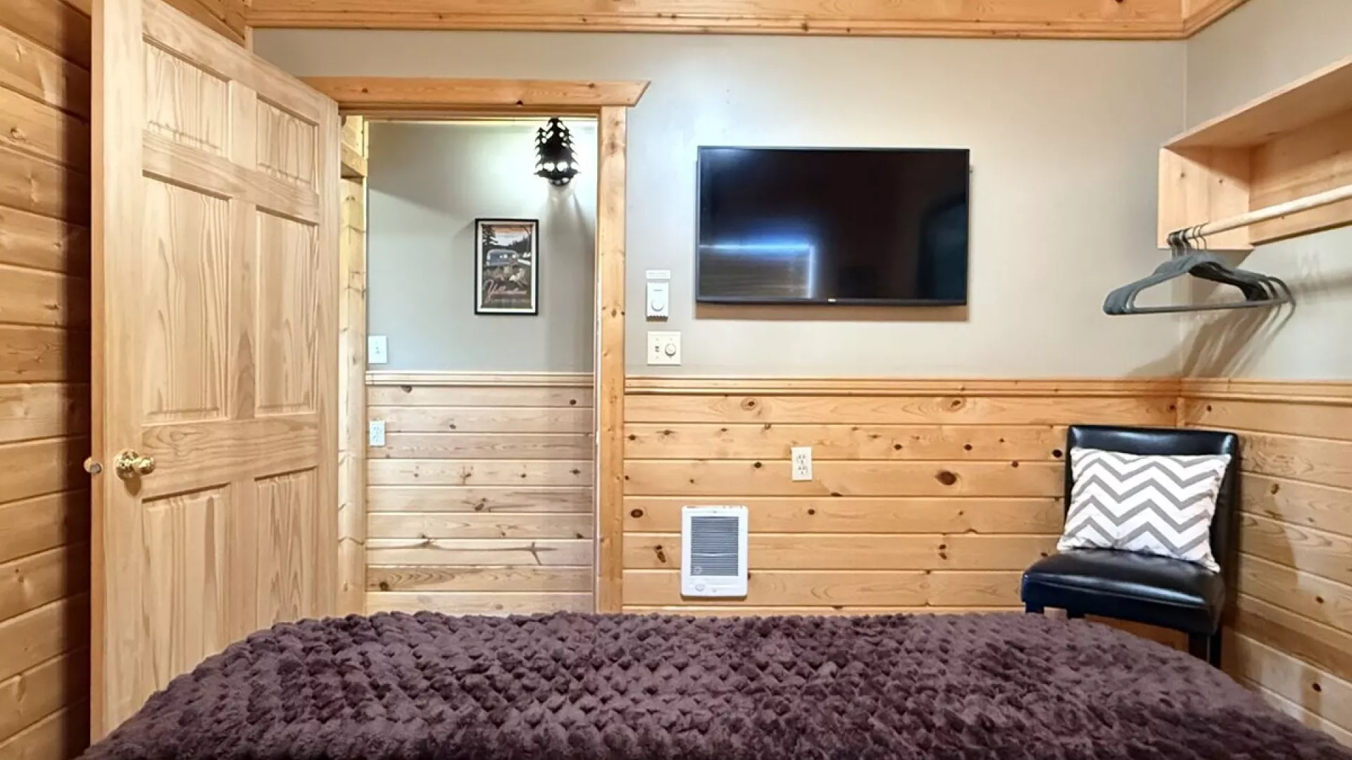 Across from the bed is a flat-screen TV—simple, unobtrusive, ready for late-night movies or quiet mornings.
