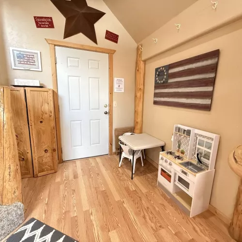A small play kitchen is here for the kiddos to enjoy.