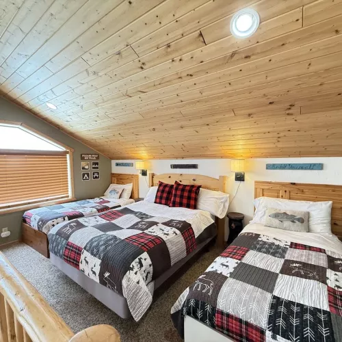 Upstairs loft with a double bed and two twin beds.