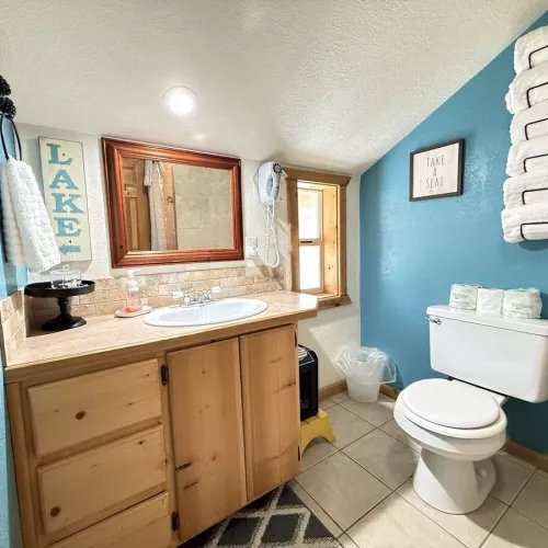 Upstairs bathroom with a full sink vanity, toilet, and standing shower.
