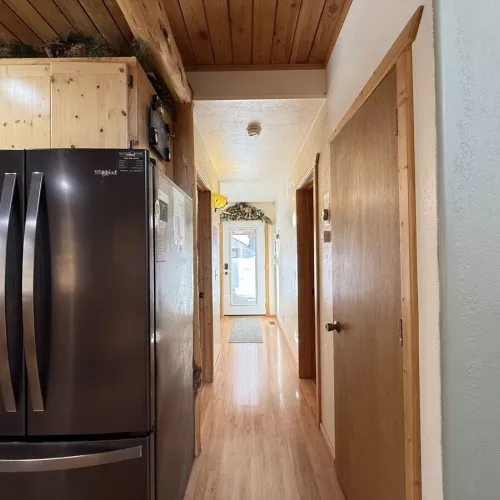 Hallway view of the kitchen and access to the bathroom and laundry room ahead.