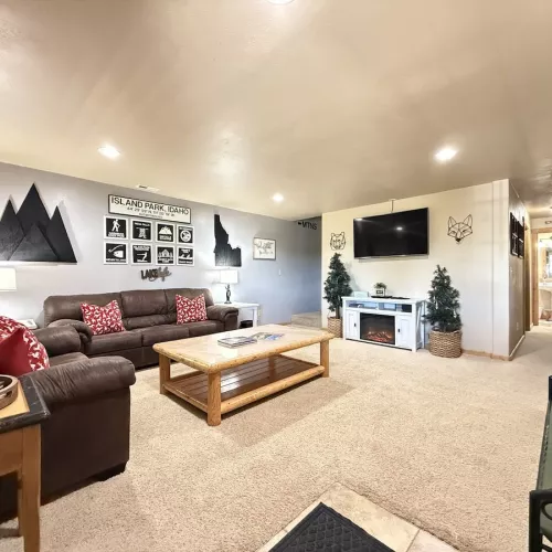Upon entrance of the cabin you view the downstairs living room. Equipped with a smart tv and seating to relax during your stay.