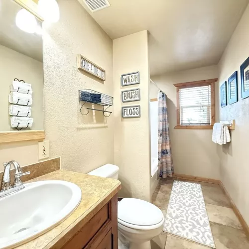 Upstairs bathroom with shower tub combo, toilet, and sink vanity.