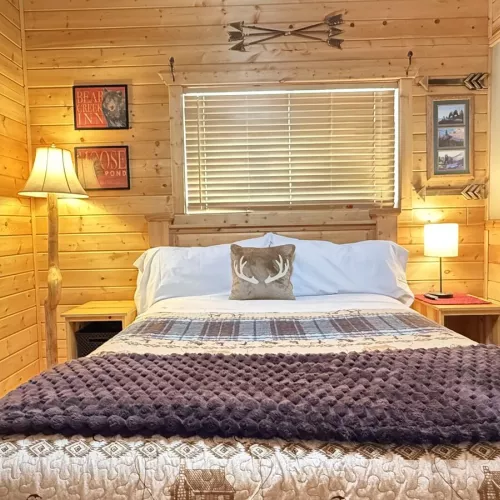 At the center of the room is a queen-sized bed with a chunky wood frame bringing that raw, rustic charm.