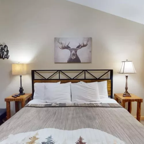 First bedroom with a king size bed, seating, and closet space.