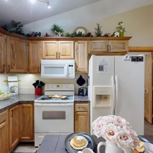 A full size kitchen with a dining room table to seat everyone.